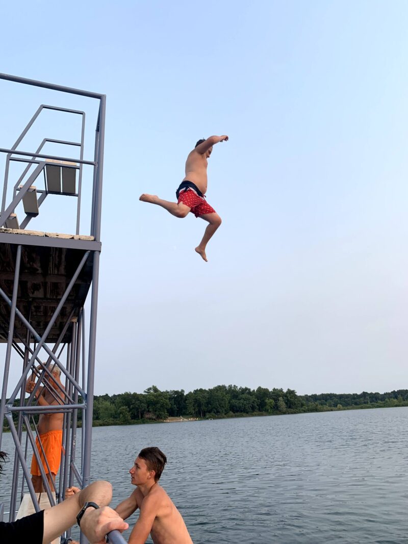 student jumping from pontoon